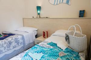 a bedroom with two beds and a basket on the bed at Villetta Tina in Vada