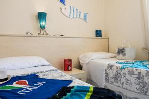 a bedroom with two beds and a fish on the wall at Villetta Tina in Vada