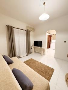 a living room with two beds and a television at Gorgyra - Boutique Apartment in Karlovasi