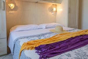 a bed with a hat sitting on top of it at Villetta Tina in Vada