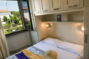 a small bed in a small room with a window at Villetta Tina in Vada