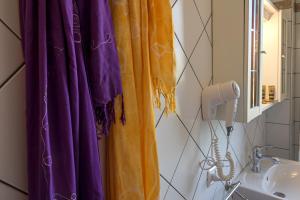a bathroom with purple and yellow curtains and a sink at Villetta Tina in Vada