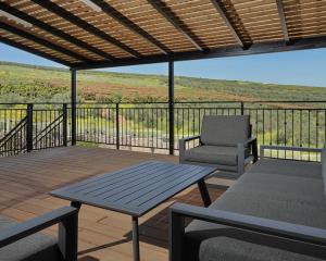 a patio with a table and a chair on a deck at וילה ג'נסיס - וילה מהממת למשפחות עם בריכה פרטית מחוממת ליד הכנרת in Migdal