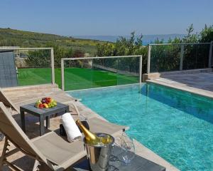 a swimming pool with a table and chairs next to at וילה ג'נסיס - וילה מהממת למשפחות עם בריכה פרטית מחוממת ליד הכנרת in Migdal
