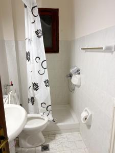 a bathroom with a toilet and a shower curtain at Gorgyra - Boutique Apartment in Karlovasi +5 photos