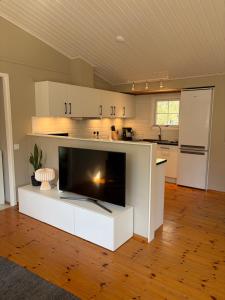 a kitchen with a large tv on a white counter at Semesterhus nära Köpingsvik in Köpingsvik