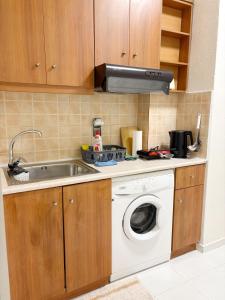 a kitchen with a sink and a washing machine at Gorgyra - Boutique Apartment in Karlovasi
