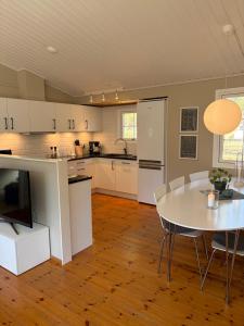 a kitchen with a white table and a table and chairs at Semesterhus nära Köpingsvik in Köpingsvik