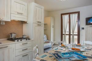 a kitchen with white cabinets and a table with food on it at Villetta Tina in Vada