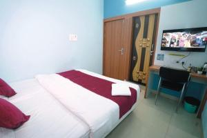 a bedroom with a bed and a desk and a television at Hotel Sutlaj in Indore