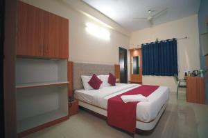 a bedroom with a large white bed with red pillows at Hotel Sutlaj in Indore +11 photos