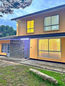 a house with yellow windows and a stone wall at Luxury 4 BR Homely Apt with a pool in Kisumu