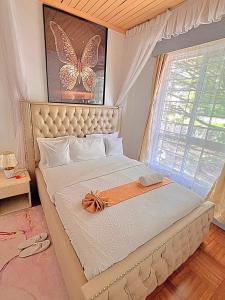 a bedroom with a large bed with a butterfly painting on the wall at Luxury 4 BR Homely Apt with a pool in Kisumu +39 photos