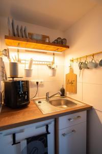 a kitchen counter with a sink and a microwave at Appartement eleven in Duisburg