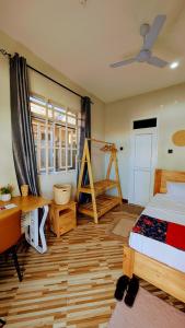 a bedroom with a bed and a desk and a window at Esther & Hans Homes in Dodoma