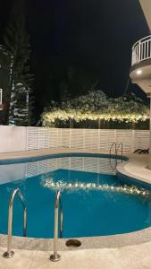 a swimming pool at night with lights on a building at Mikayla Cove in Negombo