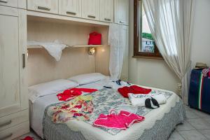 a bedroom with a bed with clothes on it at Villetta Tina in Vada