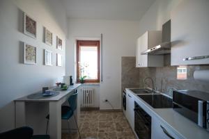 a kitchen with a sink and a table in it at Appartamento con vista città - SmartCheck-In & Wifi Fibra in Campobasso +12 photos