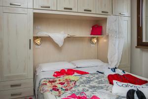 a bedroom with a bed with clothes on it at Villetta Tina in Vada