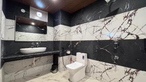 a black and white bathroom with a toilet and a sink at The Trippy Tribe Manali in Manāli