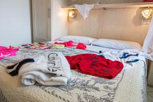a bed with clothes and towels on it at Villetta Tina in Vada