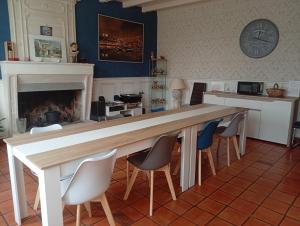 a table and chairs in a kitchen with a fireplace at Domaine la belle charentaise in Chadenac