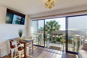 a living room with a table and a balcony at La Mare Vita in Carolina Beach +42 photos
