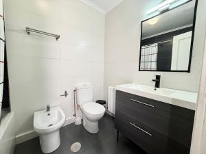 a white bathroom with a toilet and a sink at Perez del Molino - 5806 in Isla