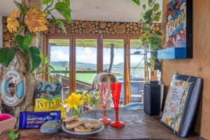 a table with a plate of food and a glass at Cosy rustic cabin with hot tub and country views in Llanelli +51 photos