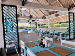 a dining room with blue tables and chairs at Naiharn Beach Resort - SHA Plus Extra in Nai Harn Beach