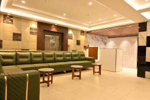 a waiting room with a green couch and stool at VMR Hotel Port Blair in Jangli Ghāt
