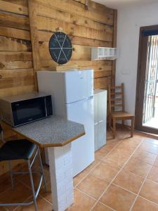 a kitchen with a refrigerator and a clock on the wall at Casa Amigos Rural in Cuevas del Almanzora