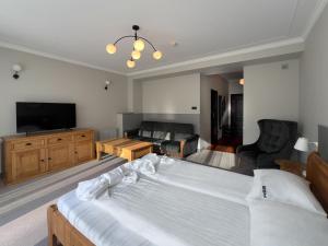 a bedroom with a large bed and a living room at Willa 654 in Szklarska Poręba