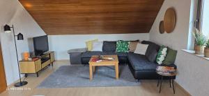 a living room with a couch and a tv at Ferienwohnung mit Kreuzbergblick in Bischofsheim an der Rhön