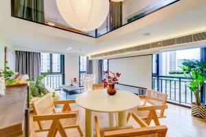 a living room with a table and chairs and a balcony at Yangji Yeju in Zhuhai