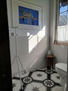 a bathroom with a toilet and a tile floor at Ulęgałki Roztocze Stodoła in Jacnia