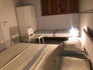 a small room with two beds and a chair at Sicily Sud-Est in Avola