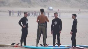 a group of men standing on the beach with surfboards at Tamraght Sunny apartment in Tamraght Ouzdar