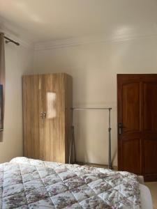 a bedroom with a bed and a wooden cabinet at Tamraght Sunny apartment in Tamraght Ouzdar