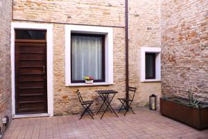 a patio with chairs and a table in front of a building at Residenza Toscanini in Ravenna
