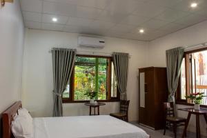 a bedroom with a bed and a window and chairs at Hue garden homestay in Thôn Trường Giang