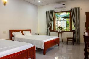 a bedroom with two beds and a window at Hue garden homestay in Thôn Trường Giang