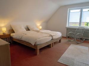 a bedroom with a bed with two lamps and a window at Xantenglück in Xanten