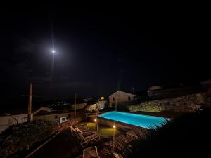 a swimming pool at night with a light in the sky at Las Pazuelas in Parrillas