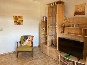 a living room with a tv and a chair at Seenplatte in Malchow