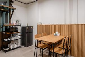 a kitchen with a wooden table and a refrigerator at Cool cozy In Yaowarat in Bangkok