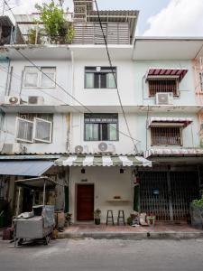 a large white building with a store front at Cool cozy In Yaowarat in Bangkok