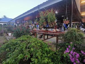 a picnic table with plants in front of a building at Hosanna village in Semporna +2 photos