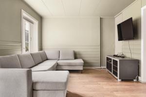 ein Wohnzimmer mit Sofa und Fernseher in der Unterkunft Trolltunga Basic in Tyssedal