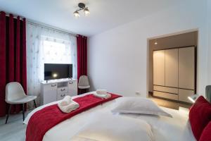 a bedroom with a large bed with a red blanket at Vila Petro in Iaşi +1 photo
